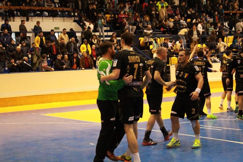 Timișoreanul Șimicu, cu 7, îl îmbrățișează pe veteranul portar Rudi Stănescu, autor a 16 intervenții, dintre care două aruncări de la 7 metri apărate pe fondul revenirii Constanței